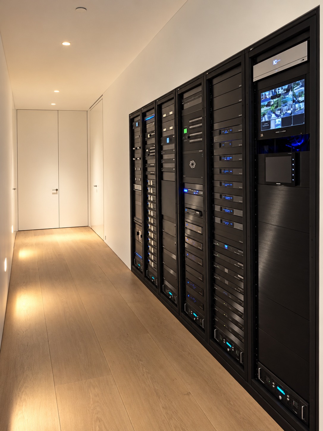 Five black AV equipment racks integrated into a modern hallway